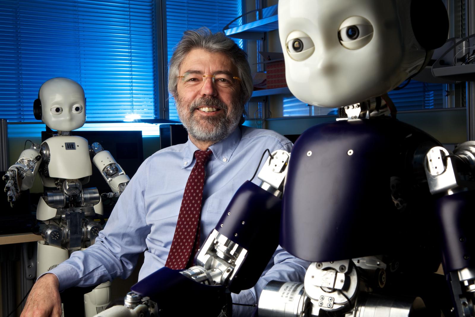 Giulio Sandini, direttore del dipartimento di Robotica, Scienze Cognitive e del Cervello dell’Istituto Italiano di Tecnologia di Genova, sorride accanto al robot antropomorfo iCub