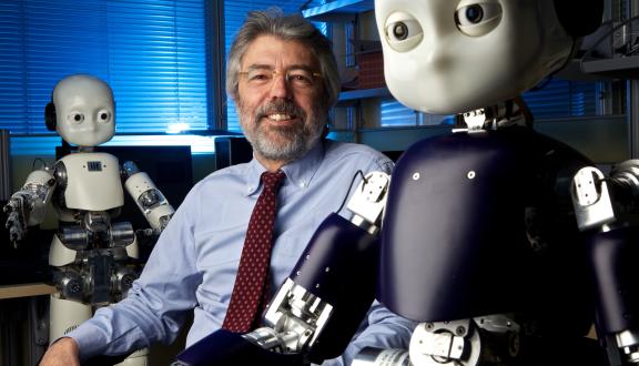 Giulio Sandini, direttore del dipartimento di Robotica, Scienze Cognitive e del Cervello dell’Istituto Italiano di Tecnologia di Genova, sorride accanto al robot antropomorfo iCub