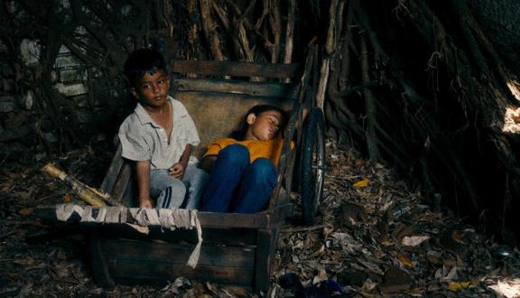Due bambini dormono in un deposito di rifiuti: scena tratta dal film Lost land 
