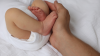 mano paterna e piede di neonato