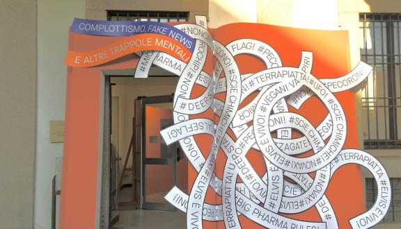 L'ingresso della mostra "Complottismo, fake news e altre trappole mentali", che riproduce la forma di un grande libro aperto attraverso cui si passa