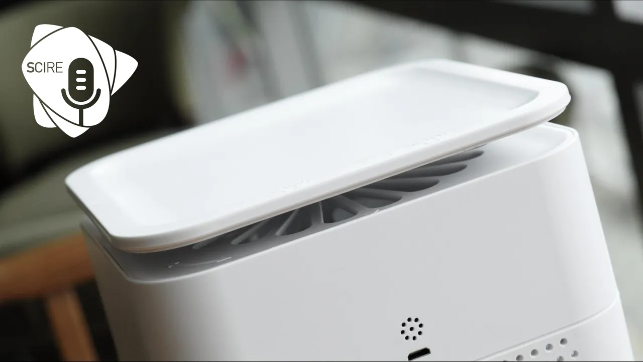 Un purificatore d'aria bianco, di forma squadrata, in primo piano in una stanza.