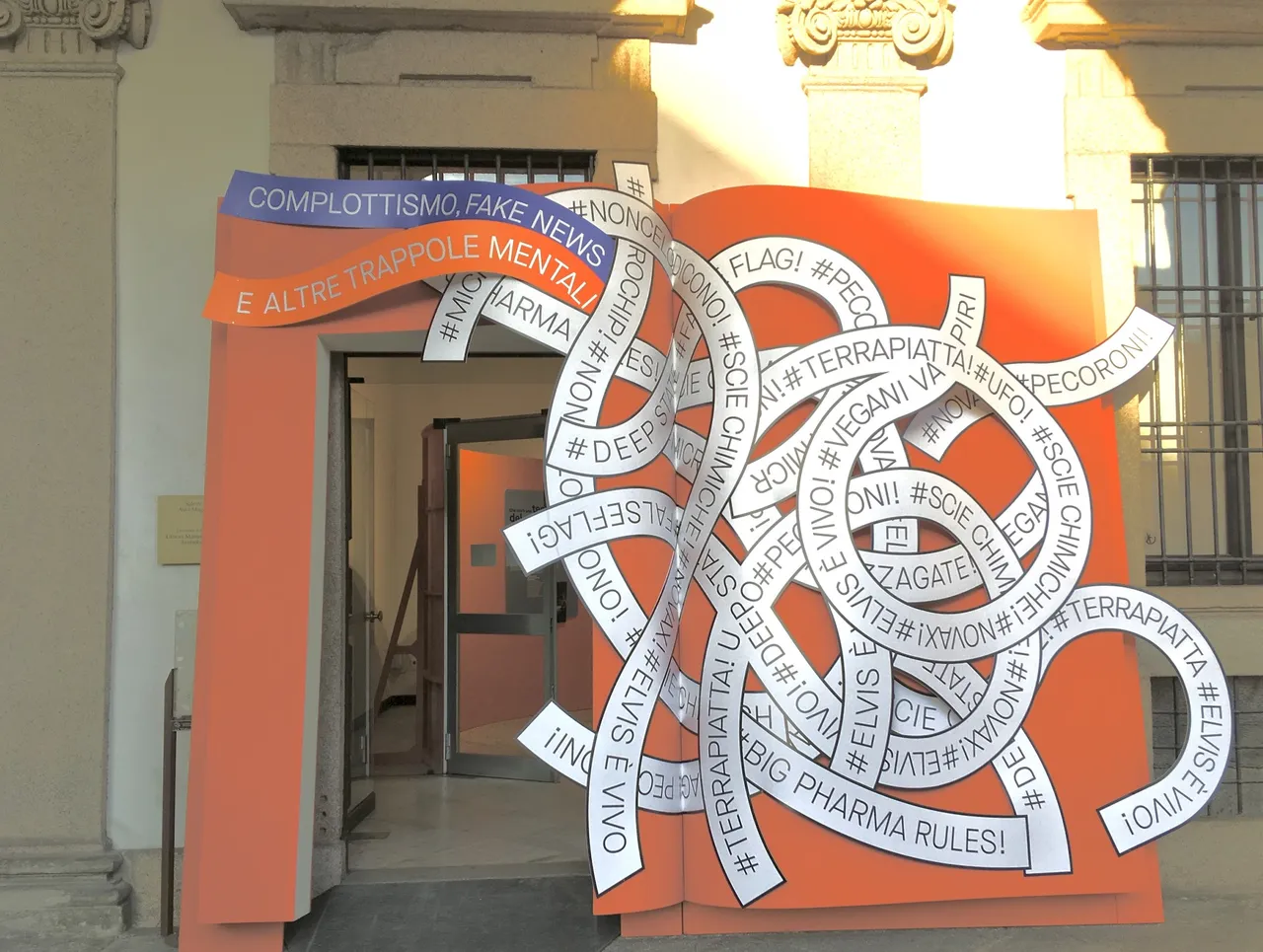 L'ingresso della mostra "Complottismo, fake news e altre trappole mentali", che riproduce la forma di un grande libro aperto attraverso cui si passa