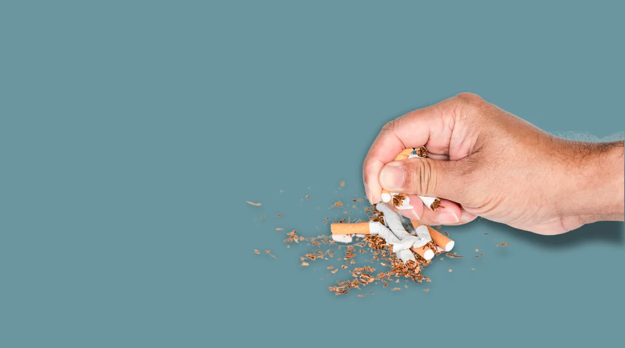 Una mano che distrugge alcune sigarette
