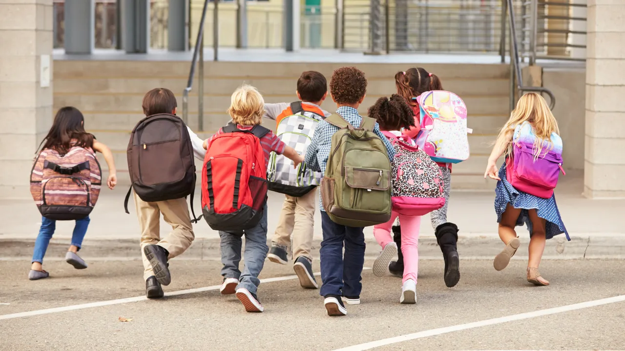 bambini che corrono con lo zaino