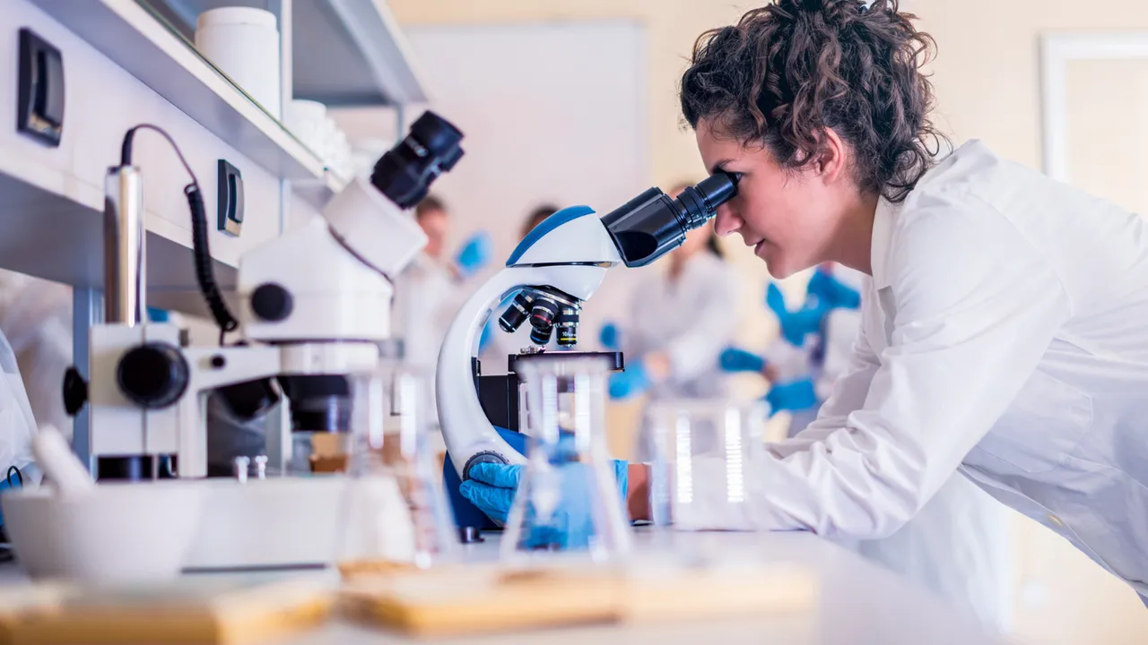 Una giovane ricercatrice al microscopio