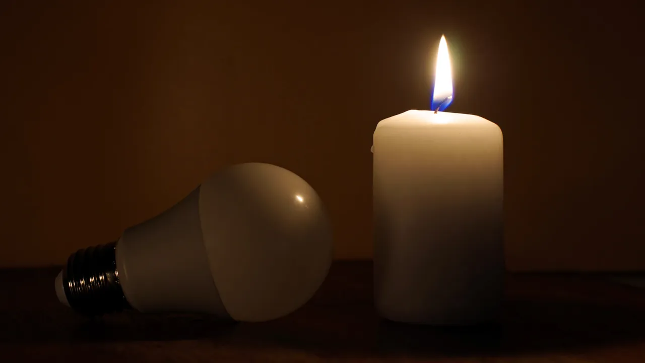 candela accesa e lampadina spenta