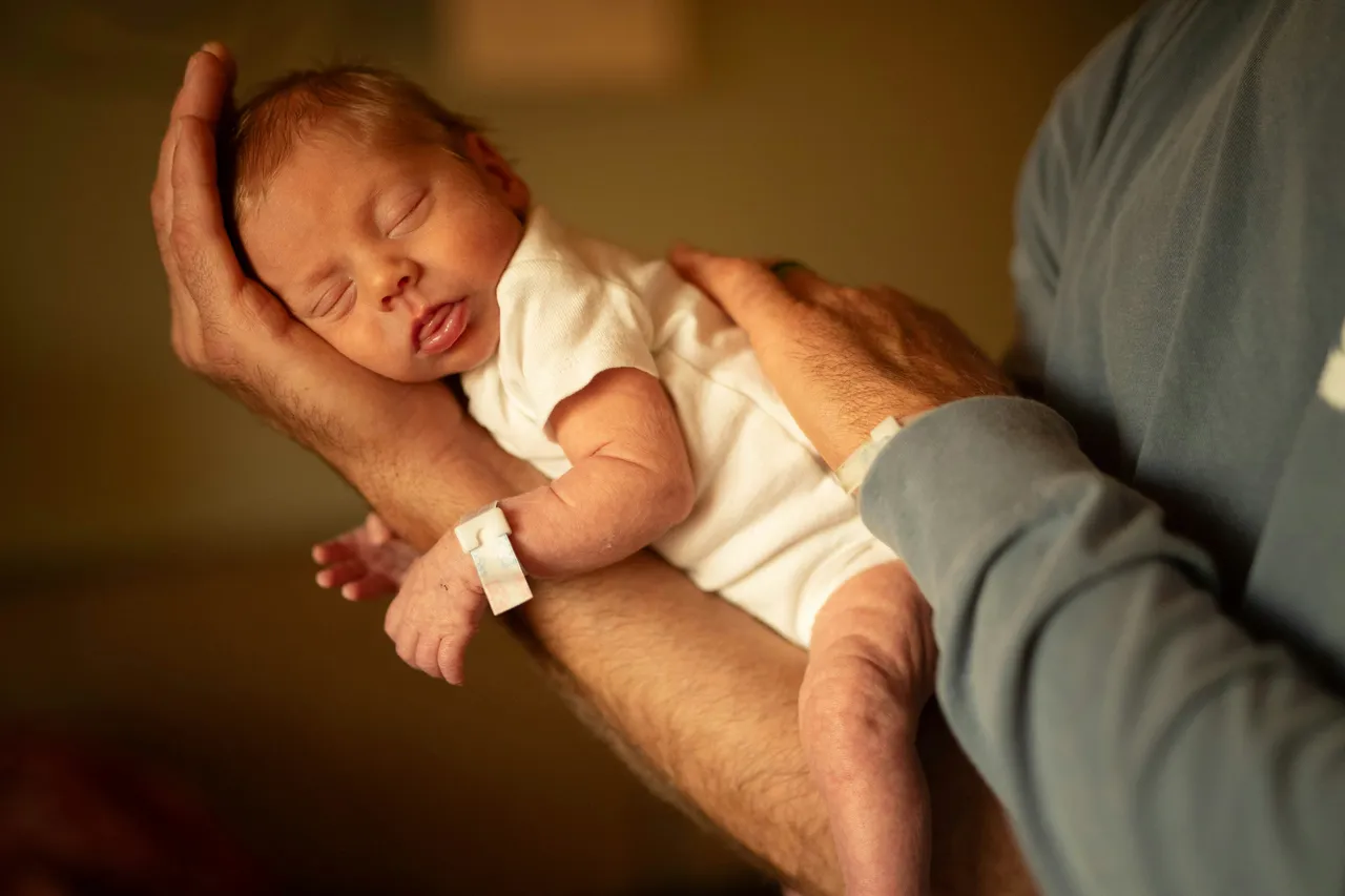 Neonato in braccio al padre