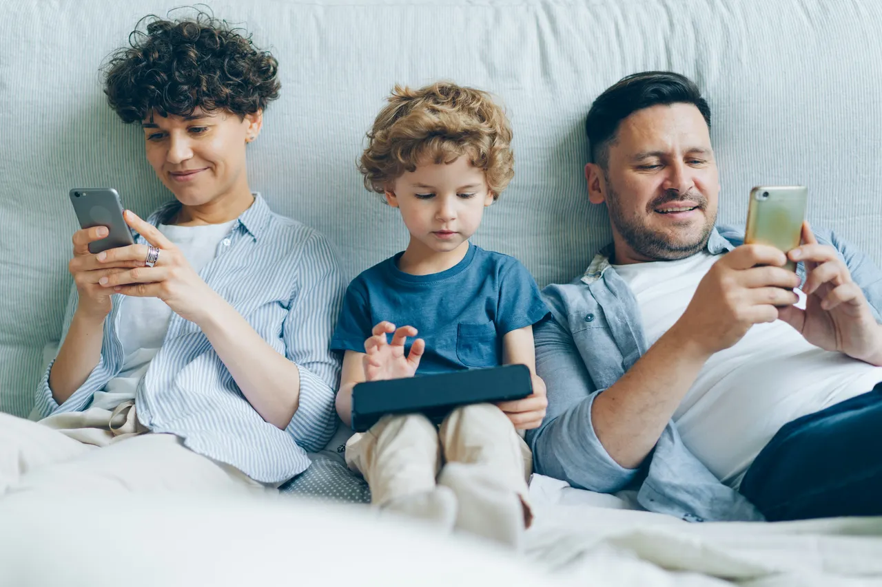 adulto e bambini che guardano lo smartphone
