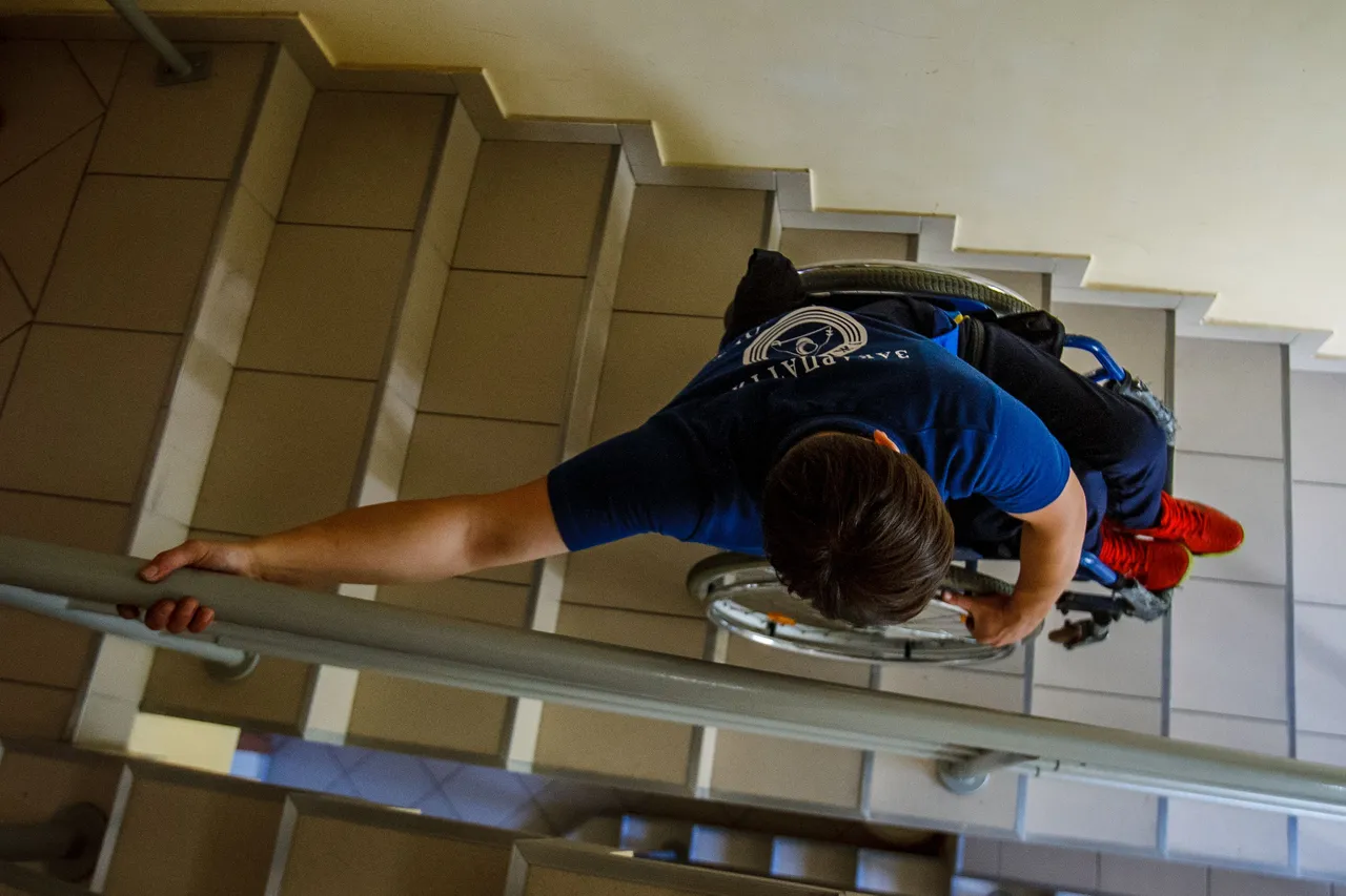 Persona sulle scale in sedia a rotelle