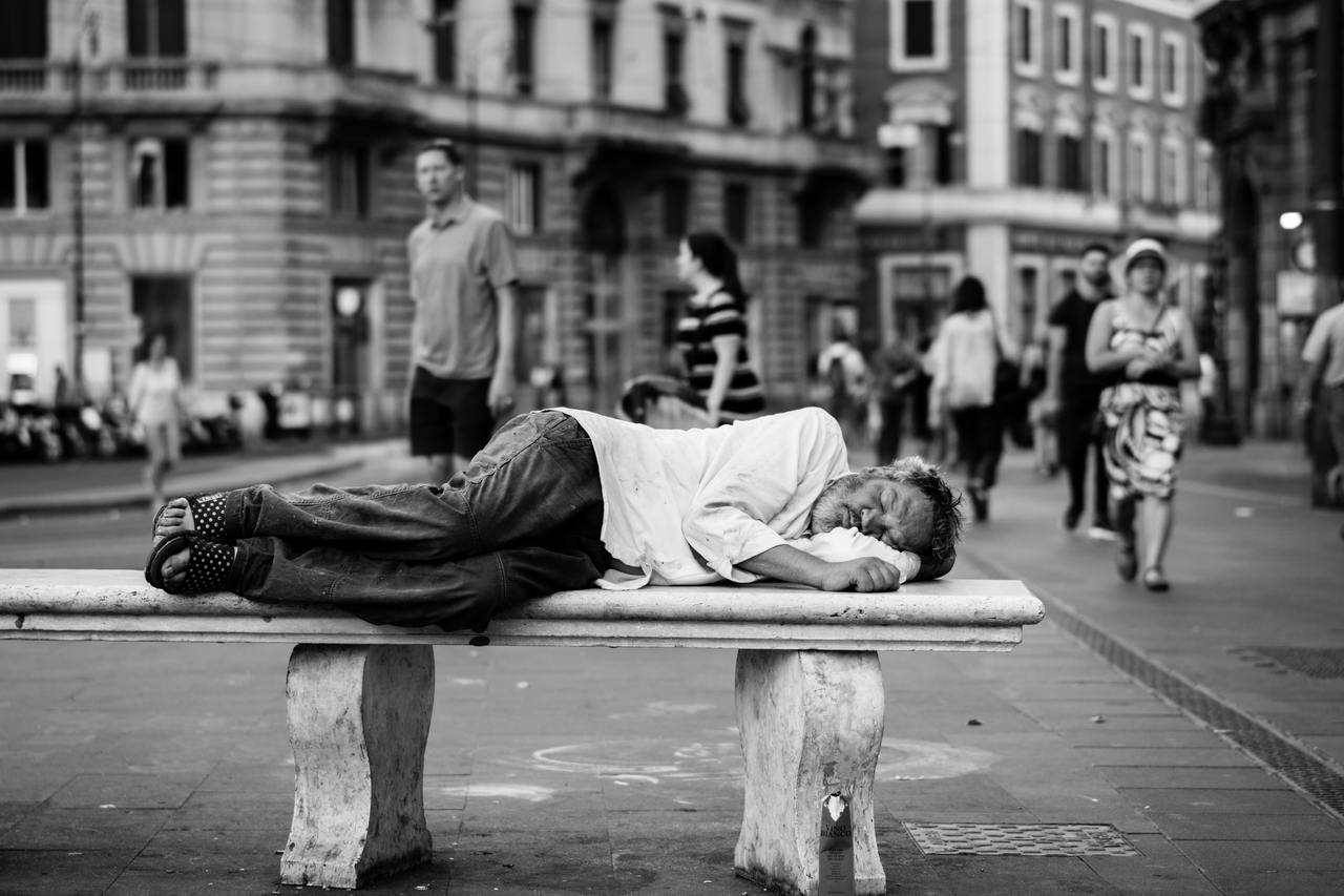 Uomo che dorme su una panchina