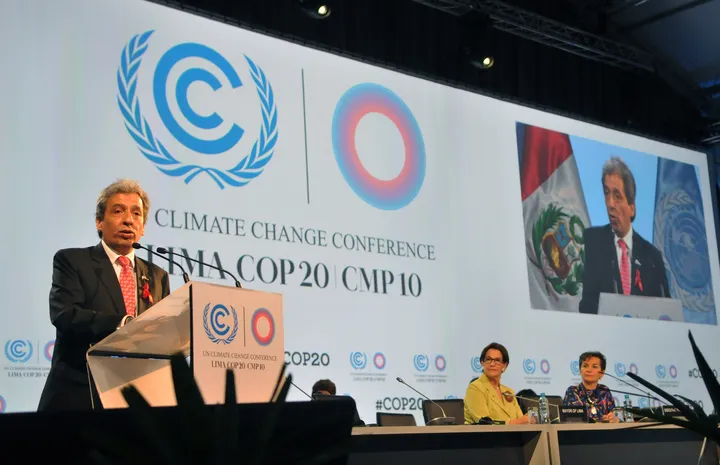 Un oratore al podio nella cerimonia d'apertura della COP20 di Lima, sotto i loghi dell'UNFCCC e della conferenza; sullo schermo il suo primo piano.