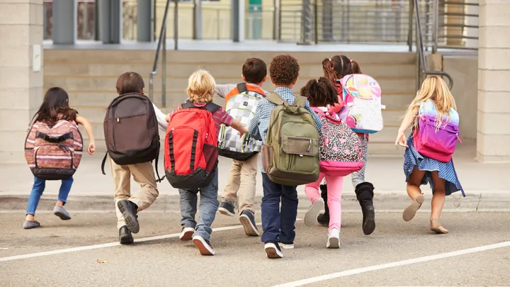 bambini che corrono con lo zaino