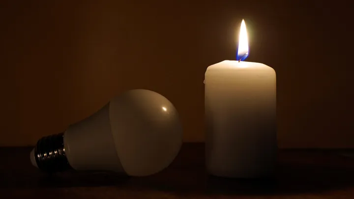 candela accesa e lampadina spenta