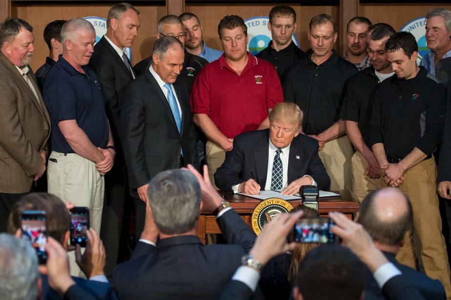 Circondato dai minatori della Rosebud Mining Company, il presidente Trump firma l'ordine esecutivo per l'indpendenza energetica presso la sede dell'EPA a Washington, DC il 28 Marzo 2017. 