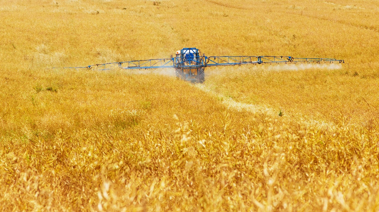 Un trattore sparge pesticidi in un campo coltivato. Credit: Pixabay. 